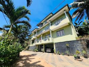 a building with a palm tree in front of it at New Blue Mount View Kandy in Kandy