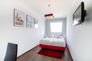 a small bedroom with a bed and a flat screen tv at Apartments IN - Bandurskiego in Szczecin +18 photos