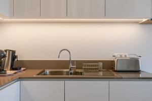 a kitchen with a sink and a toaster at Balcony Beach & Pool Access Family-Friendly Stay in Nieuwpoort