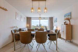 a dining room with a table and chairs at Balcony Beach & Pool Access Family-Friendly Stay in Nieuwpoort