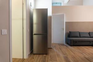 a living room with a refrigerator and a couch at Principi di Piemonte Apartments in Tirrenia +266 photos