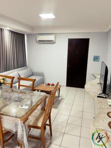 a living room with a table and a couch at Ponta de Pedra 103 in Ilha da Restinga