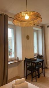 Un comedor con una mesa y una lámpara de araña. en Studio République, en Nantes