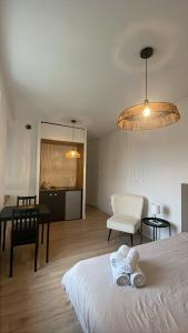 Un dormitorio con una cama y una mesa y sillas. en Studio République, en Nantes