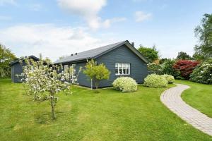 een blauw huis in een tuin met een boom bij C11690-Hemmet-Lukkebjerg-7 in Falen