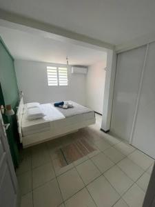 a bedroom with a bed and a window at Appartement charmant avec piscine partagée à Le François in Bois-Neuf