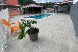 a patio with a bench and a swimming pool at Appartement charmant avec piscine partagée à Le François in Bois-Neuf +4 photos