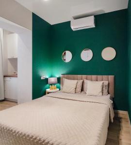 ein Schlafzimmer mit einer grünen Wand mit einem Bett in der Unterkunft Белая студия Вокзал Харьков-Пассажирский in Kharkov + 12 Fotos
