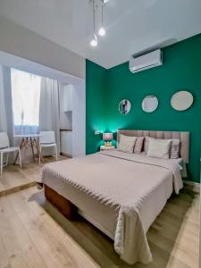 ein Schlafzimmer mit einem großen Bett mit grünen Wänden in der Unterkunft Белая студия Вокзал Харьков-Пассажирский in Kharkov