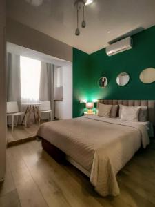 ein Schlafzimmer mit einem großen Bett mit einer grünen Wand in der Unterkunft Белая студия Вокзал Харьков-Пассажирский in Kharkov