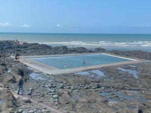 ウエストワード・ホーにあるDeluxe Seaside Flat easy accessの海辺の岩の上のスイミングプール