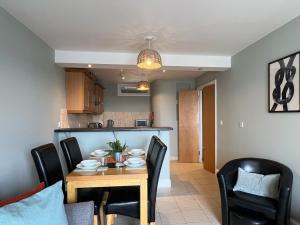 a dining room and kitchen with a table and chairs at Deluxe Seaside Flat easy access in Westward Ho