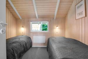 two beds in a small room with a window at C11725-Hemmet-Strandvaenget-23 in Falen
