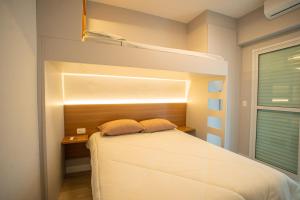 Vila BalneáriaにあるApto com Ar-condicionado e Churrasqueira Privativaのベッドルーム1室(ベッド1台、窓付きの二段ベッド1組付)