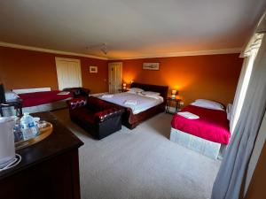 a hotel room with two beds and a couch at The Old Farmhouse in Dalkeith