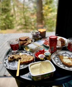 Una mesa con platos de comida encima. en Quiet Anomaly Glamping Forest & Wellness Retreat Adults Only, en Pirkenhammer