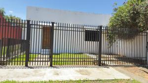 a black fence with a gate in front of a yard at Casa kuarahy in Asuncion
