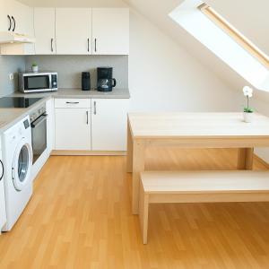 eine Küche mit weißen Schränken, einer weißen Waschmaschine und einem Trockner in der Unterkunft SUNNYHOME Monteurwohnungen und Apartments in Schwandorf in Schwandorf in Bayern