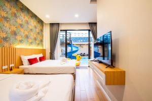 a hotel room with two beds and a tv at Ice Dragon Pool Villa ไอซ์ดราก้อน พูลวิลล่า in Ban Map Fakthong +47 photos