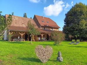 a house with a heart sculpture in the yard at Amtawa - Bien-être et Ressourcement in Kirchberg