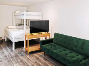 a living room with a green couch and a bed at Reef Lodge in Newquay