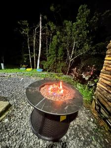 a fire pit sitting on a table in a yard at Cabaña con fogata BBQ y ríos cerro azul in Los Altos de Cerro Azul