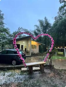a bench with a heart in front of a house at Cabaña con fogata BBQ y ríos cerro azul in Los Altos de Cerro Azul +4 photos