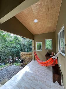 a patio with a hammock in a room at Cabaña con fogata BBQ y ríos cerro azul in Los Altos de Cerro Azul