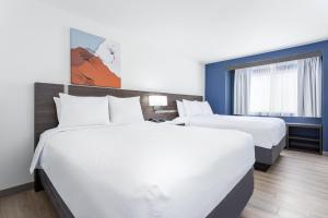 two beds in a hotel room with white sheets at Spark by Hilton Clarion in Clarion +47 photos