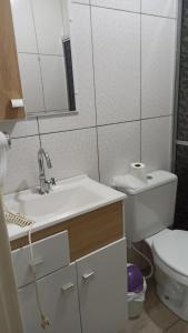 Un baño con lavabo, inodoro y espejo. en Chalé Paraíso Da Serra 02, en Gramado