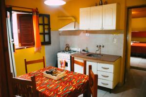 a small kitchen with a table and a sink at Cabañas Quinta Las Ruedas in San Isidro