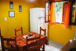 a kitchen with a table and a white refrigerator at Cabañas Quinta Las Ruedas in San Isidro