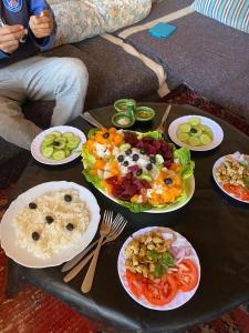 einen Tisch voller Teller mit Lebensmitteln auf einem Tisch in der Unterkunft Dar Nomad Tagounite in Zagora + 12 Fotos