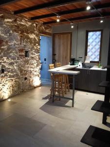 a kitchen with a table and a stone wall at Duplex Colonial Getsemani in Cartagena de Indias +16 photos