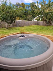 eine große Whirlpool-Badewanne im Hof in der Unterkunft Highland River Cottage with Hot Tub in Evanton