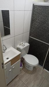 Un baño con inodoro, lavabo y ducha. en Chalé Paraíso Da Serra 02, en Gramado