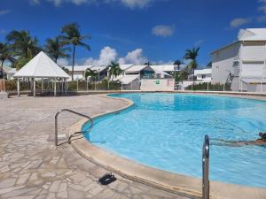 a large swimming pool in front of a building at L'oasis de Saint-François, studio An bel ti koté in Saint-François +26 photos