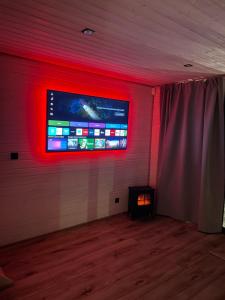 a room with a tv on a wall with red lights at Witam Karpacz 2 in Karpacz