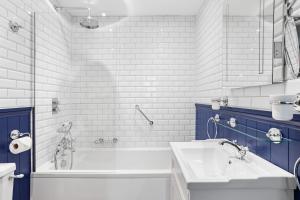 a white bathroom with a tub and a sink at 9 At The Beach, Torcross in Torcross +25 photos