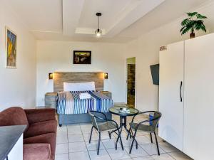 a living room with a bed and a table and chairs at Zur See - No Loadshedding in Ballito