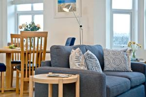 a living room with a blue couch and a table at 9 At The Beach, Torcross in Torcross