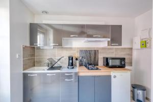 una cocina con fregadero y encimera en Le Confort du Soir - T2 - Lagnieu, en Lagnieu 3 fotos más