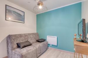 Una sala de estar con un sofá y un televisor de pantalla plana. en Le Confort du Soir - T2 - Lagnieu, en Lagnieu