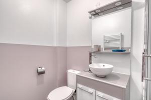 Un baño blanco con inodoro y lavabo. en Le Confort du Soir - T2 - Lagnieu, en Lagnieu