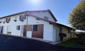 una casa bianca con porte marroni e un vialetto di Agueramonde a Mouguerre Altre 19 foto