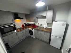 Una cocina con un frigorífico blanco y una lavadora. en Spacious Modern flat Blackburn, en Blackburn
