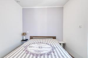 1 dormitorio con 1 cama con colcha a rayas en Le Confort du Soir - T2 - Lagnieu, en Lagnieu