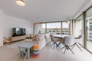 a living room with a couch and a table at Beach Front Luxe & Balcony Perfect for Families in Ostend