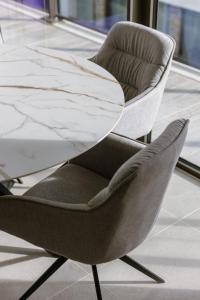 a table and a chair in a room at Beach Front Luxe & Balcony Perfect for Families in Ostend