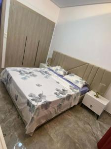 ein Schlafzimmer mit einem großen Bett mit geblümter Decke in der Unterkunft Charming apartment in Ariana